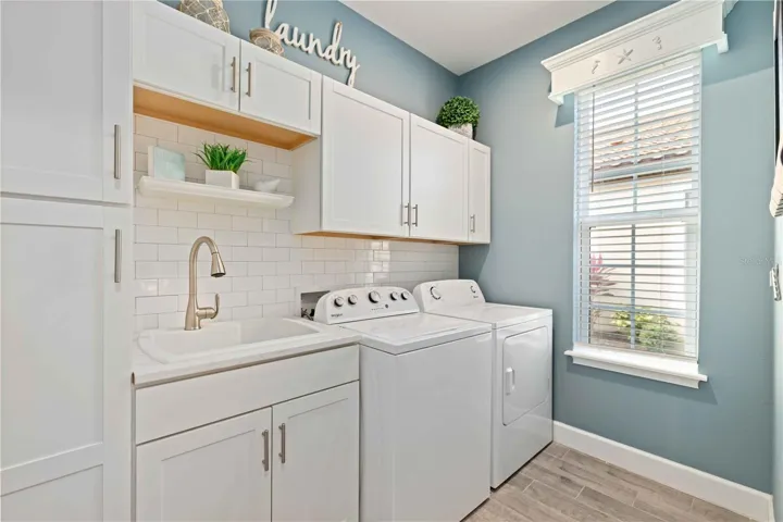 Spacious laundry room with sink and cabinetry