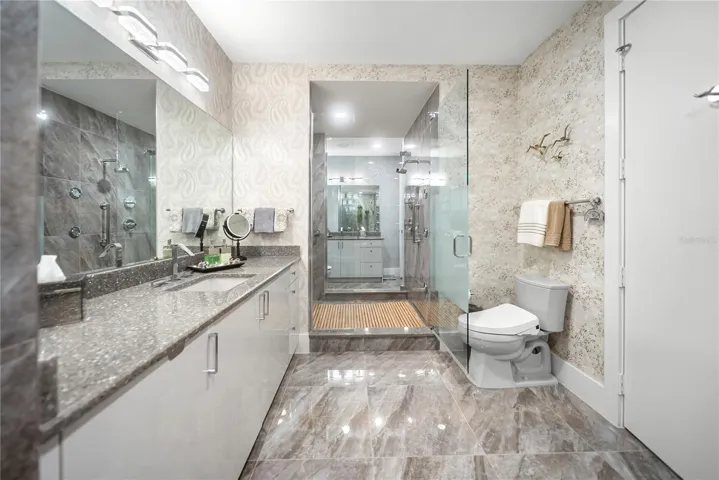 Primary bathroom - his and her side connected by spa-like shower