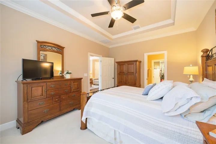 The primary suite is conveniently located off the living room and features tray ceilings and lots of natural light.