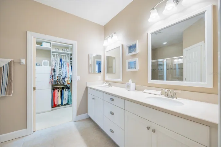 The ensuite bathroom offers practical comfort with dual vanities, a walk-in shower, and a spacious walk-in closet for easy storage.