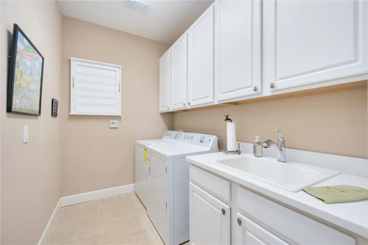 Bright, fresh, and functional, this laundry room features crisp white cabinetry, a deep utility sink, and plenty of space to tackle the day’s chores in style.