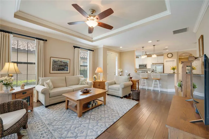An open floor plan seamlessly integrates the living, dining, and kitchen areas with crown moulding details throughout.