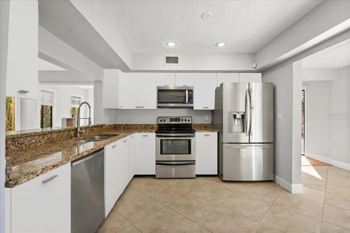 Virtually staged Beautiful kitchen with a clear view of the sparkling pool—perfect for keeping an eye on the fun