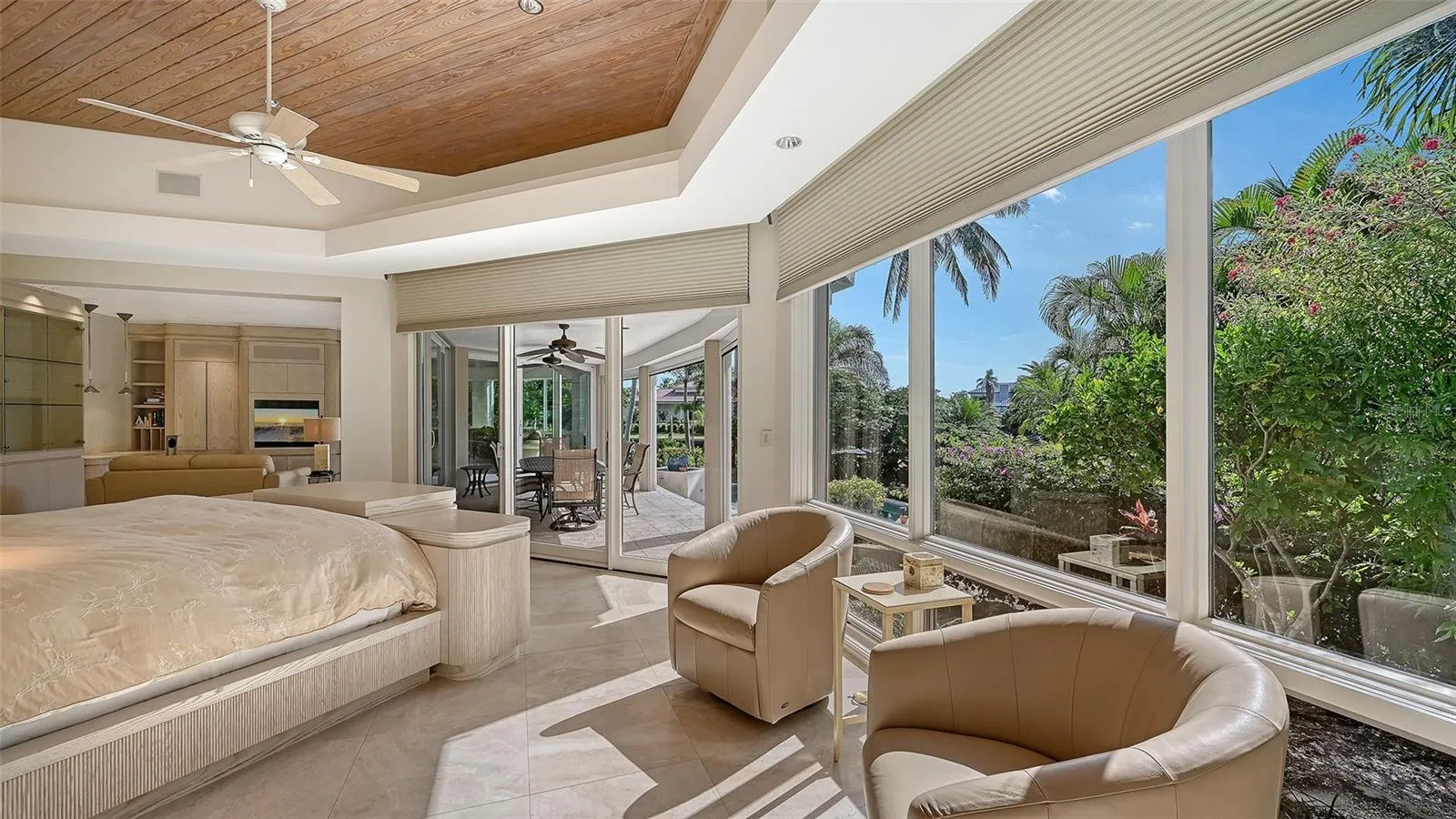 1st Floor Primary suite with picturesque views of the screened lanai, sparkling saltwater pool, and relaxing spa
