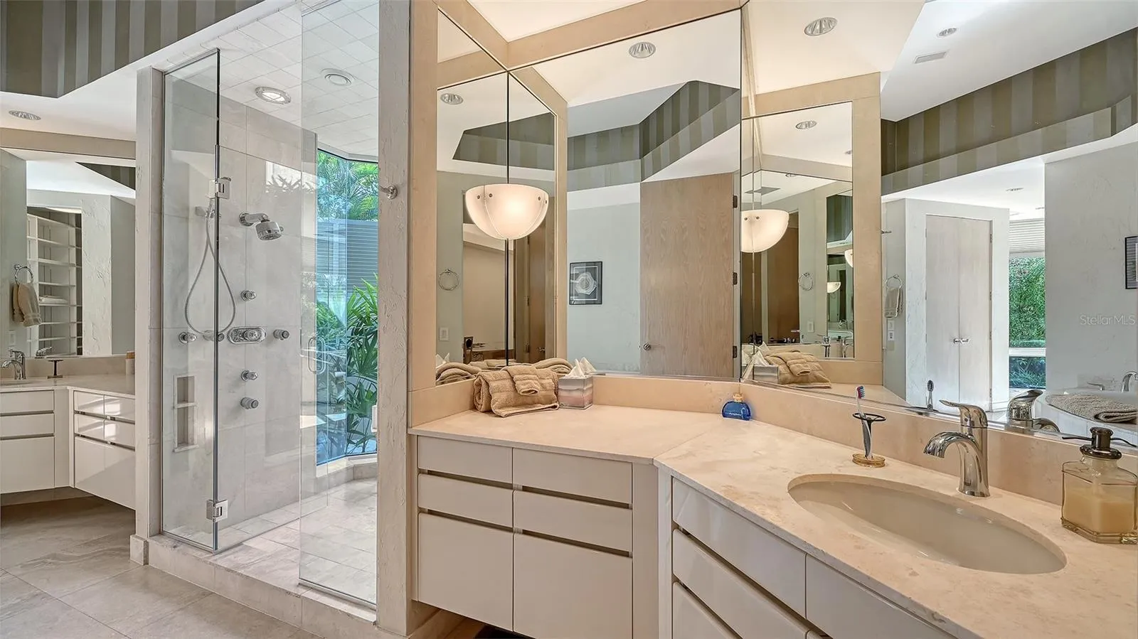 His-and-Her sinks, paired with a glass-enclosed luxury shower featuring dual shower heads
