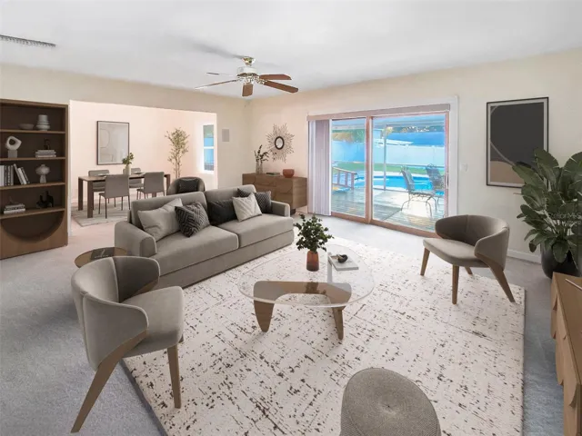This photo has virtually staged furnishings. Formal dining room is open to living room also overlooks covered and screened deck to pool creating a nice flow. Living room measures 19'x13'