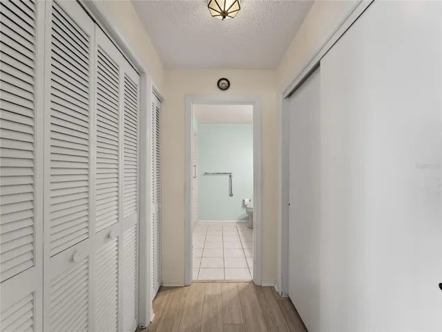 Hallway to primary bathroom with closets of both sides.
