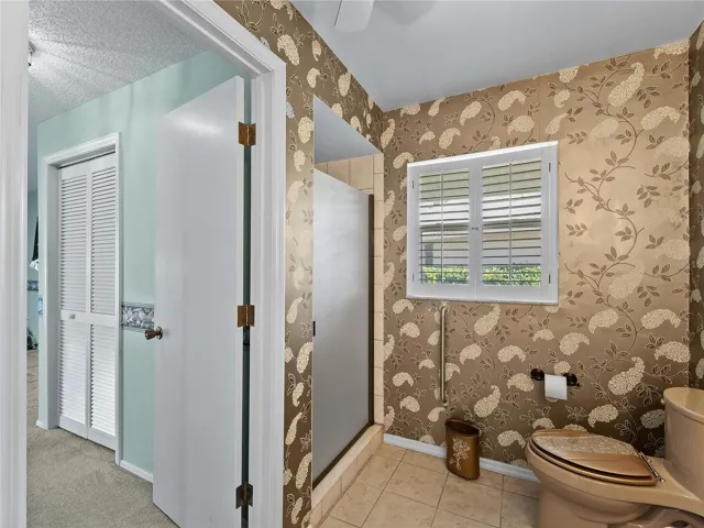 Shared bathroom showing hallway into primary bedroom on the left.