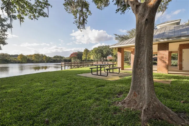 Community covered brick pavilion providing shaded seating, equipped with picnic tables.