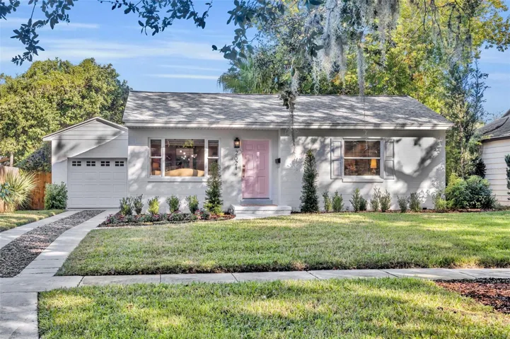 Front elevation showcasing the exterior, landscaping, and charming pink front door.