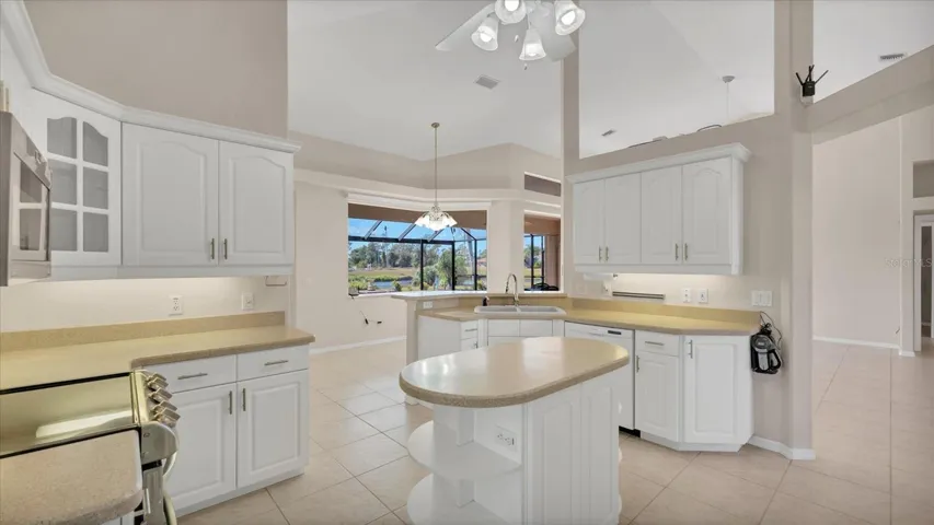 A spacious kitchen is home to abundant cabinetry accentuated with under/over cabinet lighting, a convenient prep island, and upgraded stainless steel appliances including a double oven.