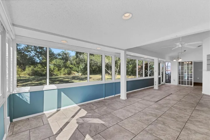 This enclosed lanai or Florida room runs the width of the house. New impact glass windows 2024 motorized privacy/sun shades.