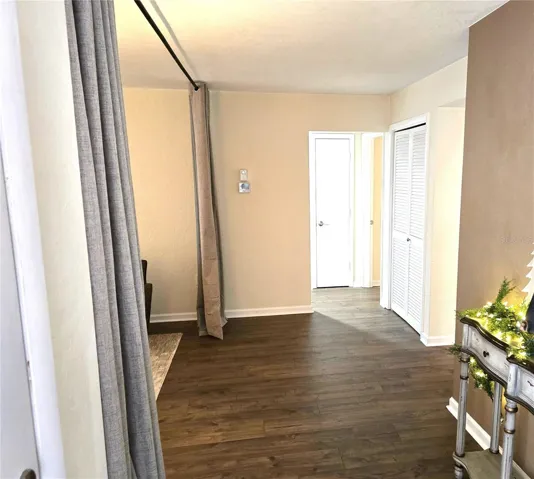 Entry foyer with living room to the left, bedrooms straight ahead and kitchen to the right