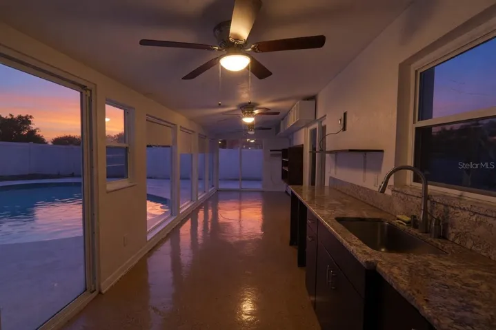 Lanai/patio with pool view and wash sink with cabinets