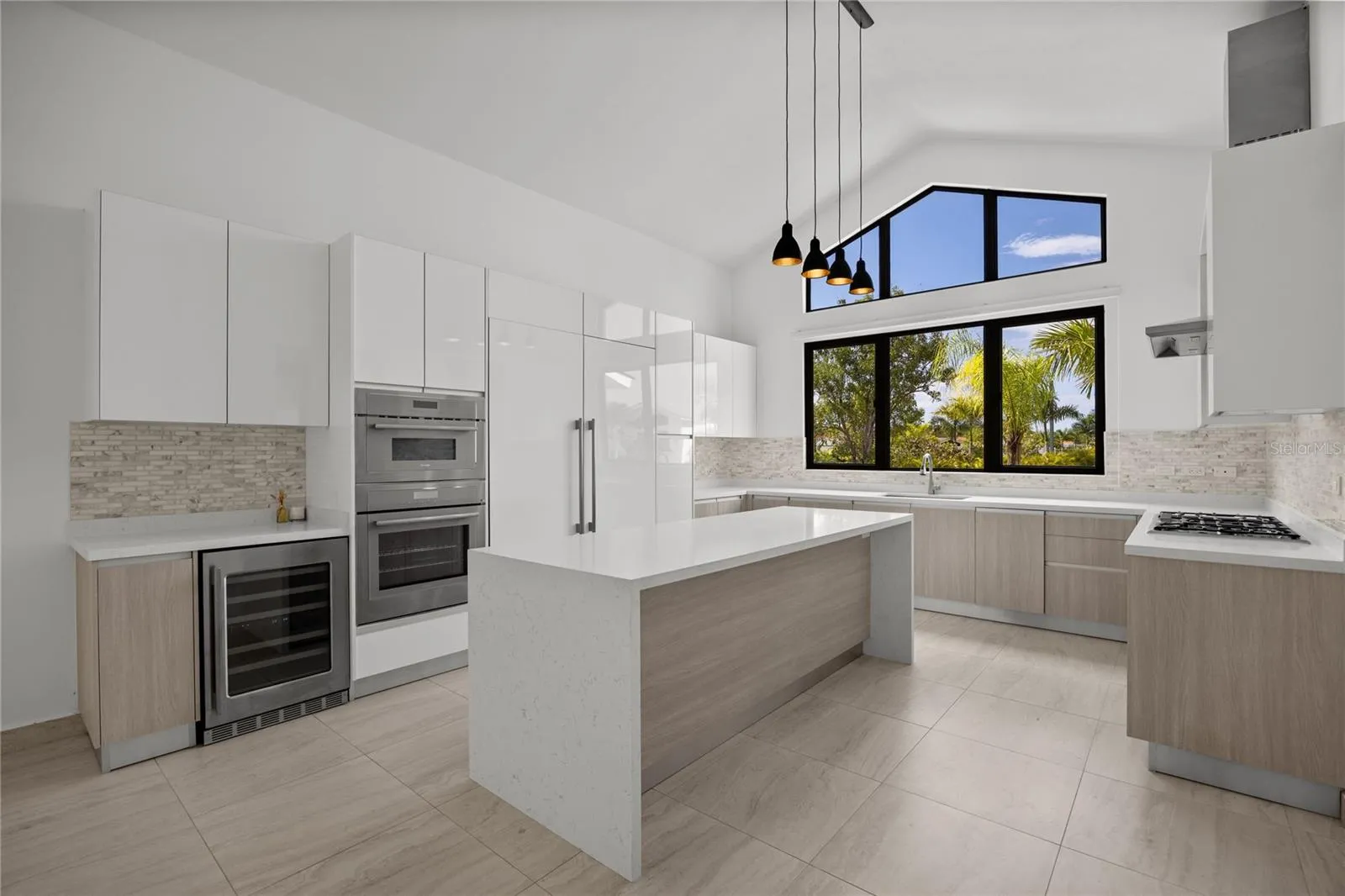 The chef’s kitchen is equipped with premium Thermador appliances, including self-contained refrigerator and freezer units, a propane cooktop, convection oven, microwave, and wine cooler. It is complemented by a Bosch dishwasher, GE disposal, vented hood, and a dedicated dry-food pantry