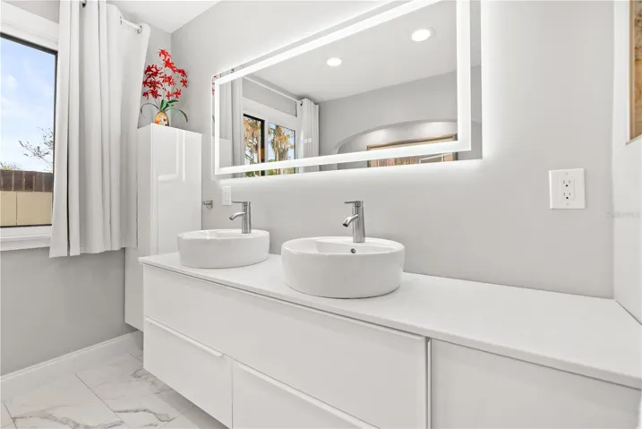 Primary bathroom his/her sinks with fog proof mirror