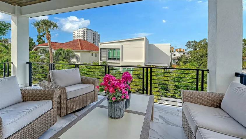 The spacious back balcony with teak ceiling and ceiling fan offers guests a retreat to enjoy coffee  overlooking the pool.