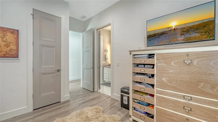 First floor bedroom with ceiling fan and attached bathroom.