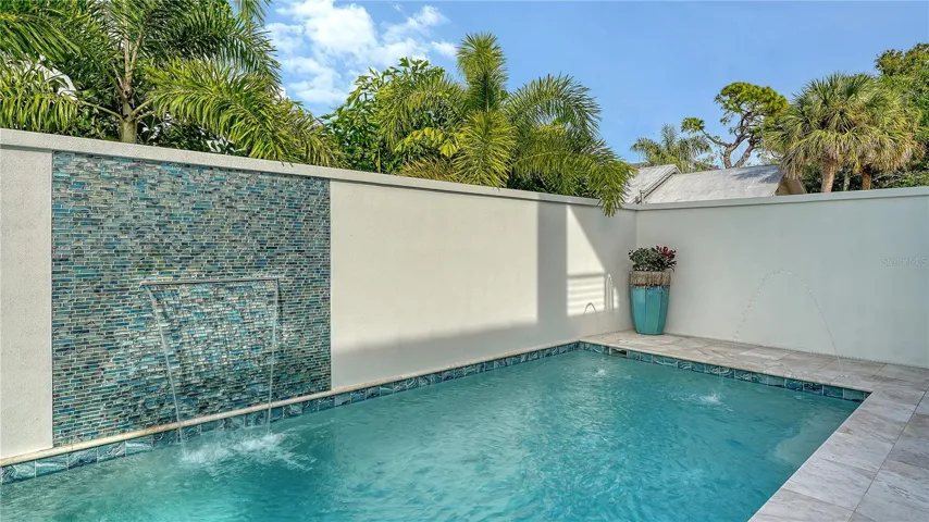 Heated pool with four fountains and waterfall feature.