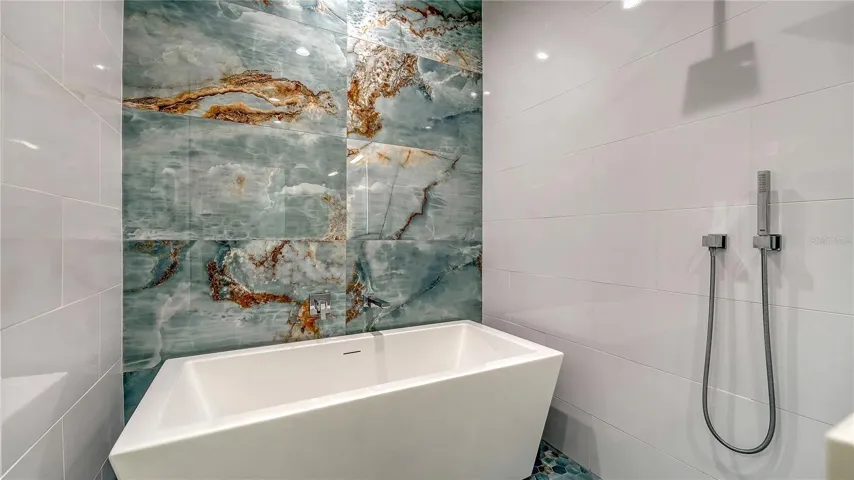 A soaking tub integrated into the walk-in shower  of the primary bathroom