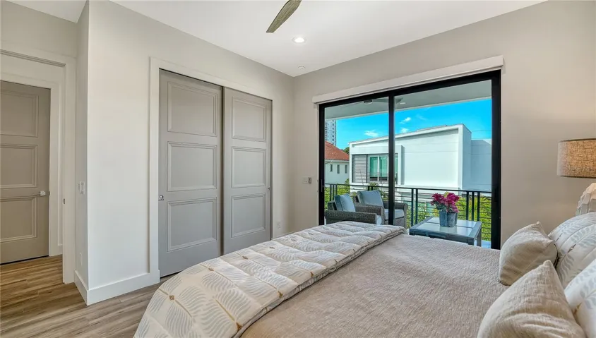 Bedroom 3 features ceiling fan, dual closets with built in shelving and drawers and sliders to the back balcony overlooking the pool.