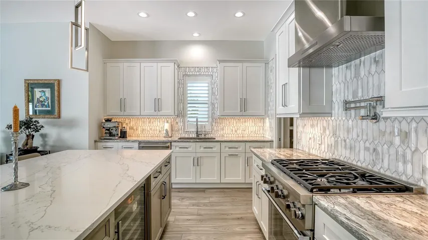 Kitchen with Thermador gas range and hood, ice maker, wine fridge and large island with seating for 7.