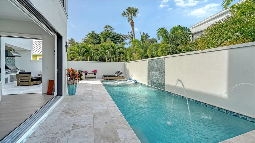 Pool with marble pool deck and access to great room.