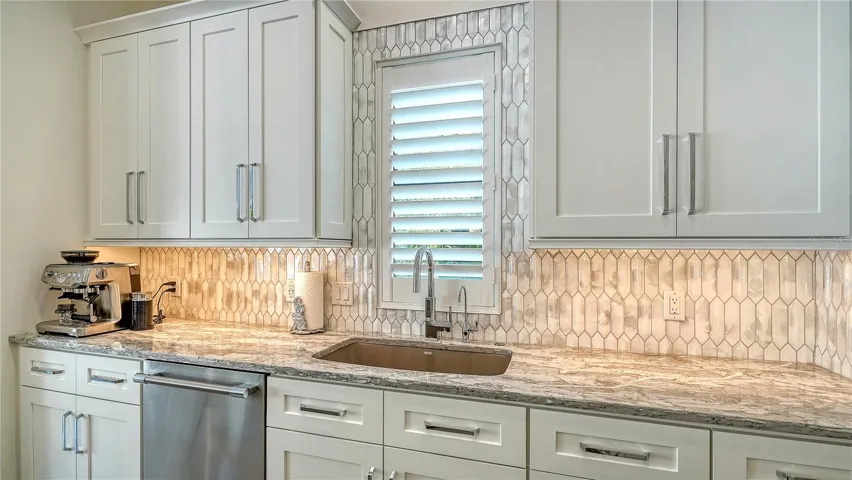 Kitchen with granite countertops, chrome fixtures, custom wood cabinets.