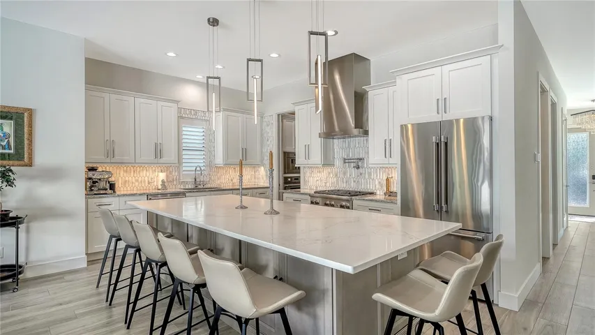 Kitchen with large island, featuring quartz countertops and Thermador stainless steel appliances.
