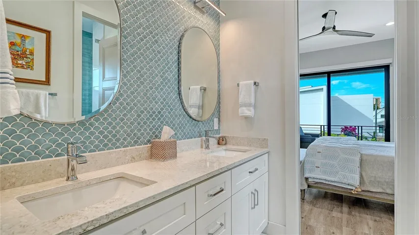 Jack and Jill bathroom features quartz countertops, dual sink vanity, chrome fixtures and walk-in shower.