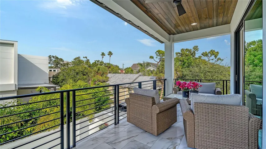 The spacious back balcony offers guests a retreat to enjoy coffee overlooking the pool.