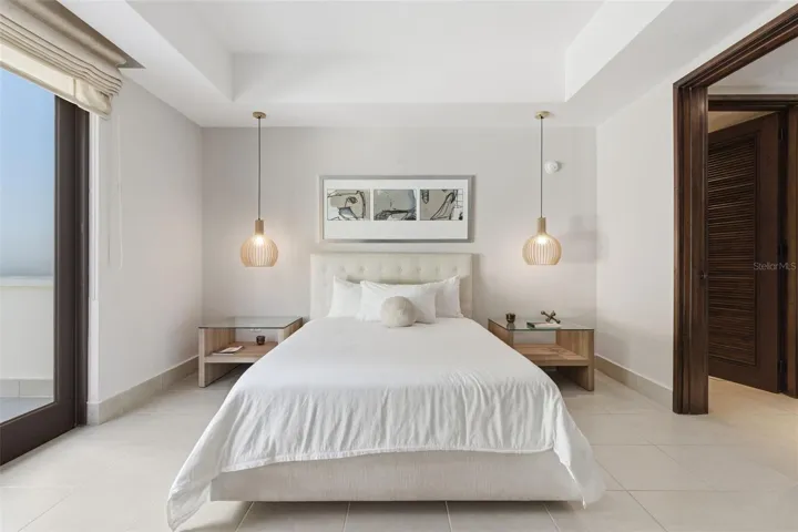 Ample bedroom with balcony overlooking the golf course and beautiful tropical scenery.