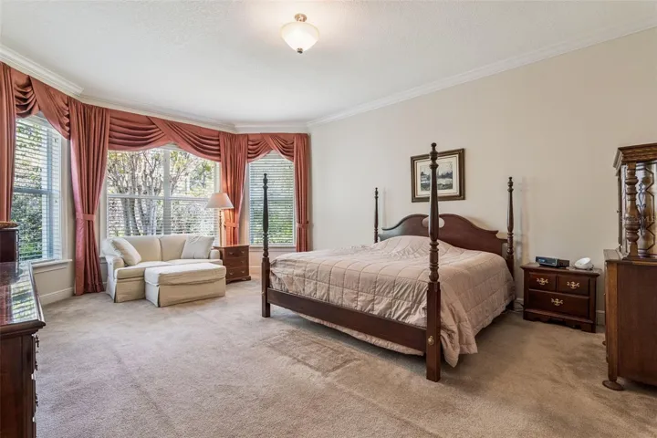 15' x 20' Primary Bedroom w/ crown molding & a conservation area view