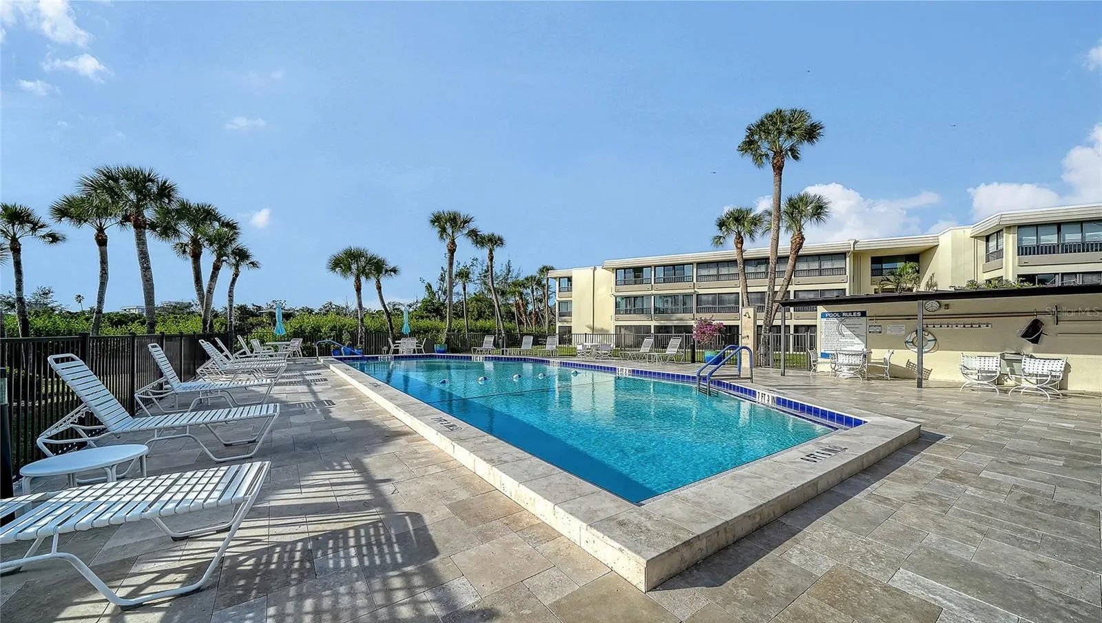 Clubhouse pool with new travertine tile deck.