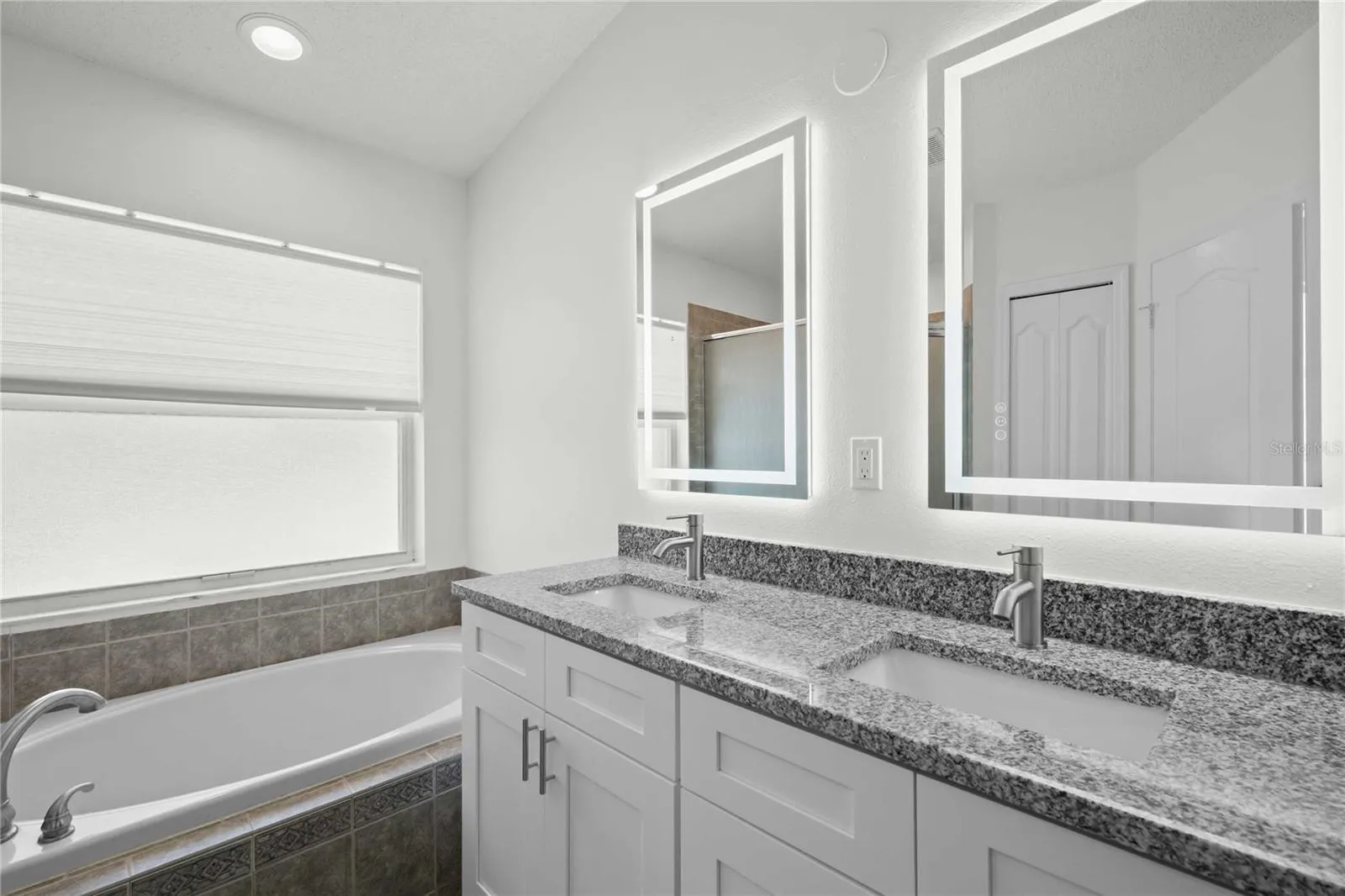 Primary Bathroom - New Dual Vanity &amp; Cabinets, New Granite Countertops, New Mirror, New Professional Paint. Bathroom has Garden Soaker Tub &amp; Shower Stall