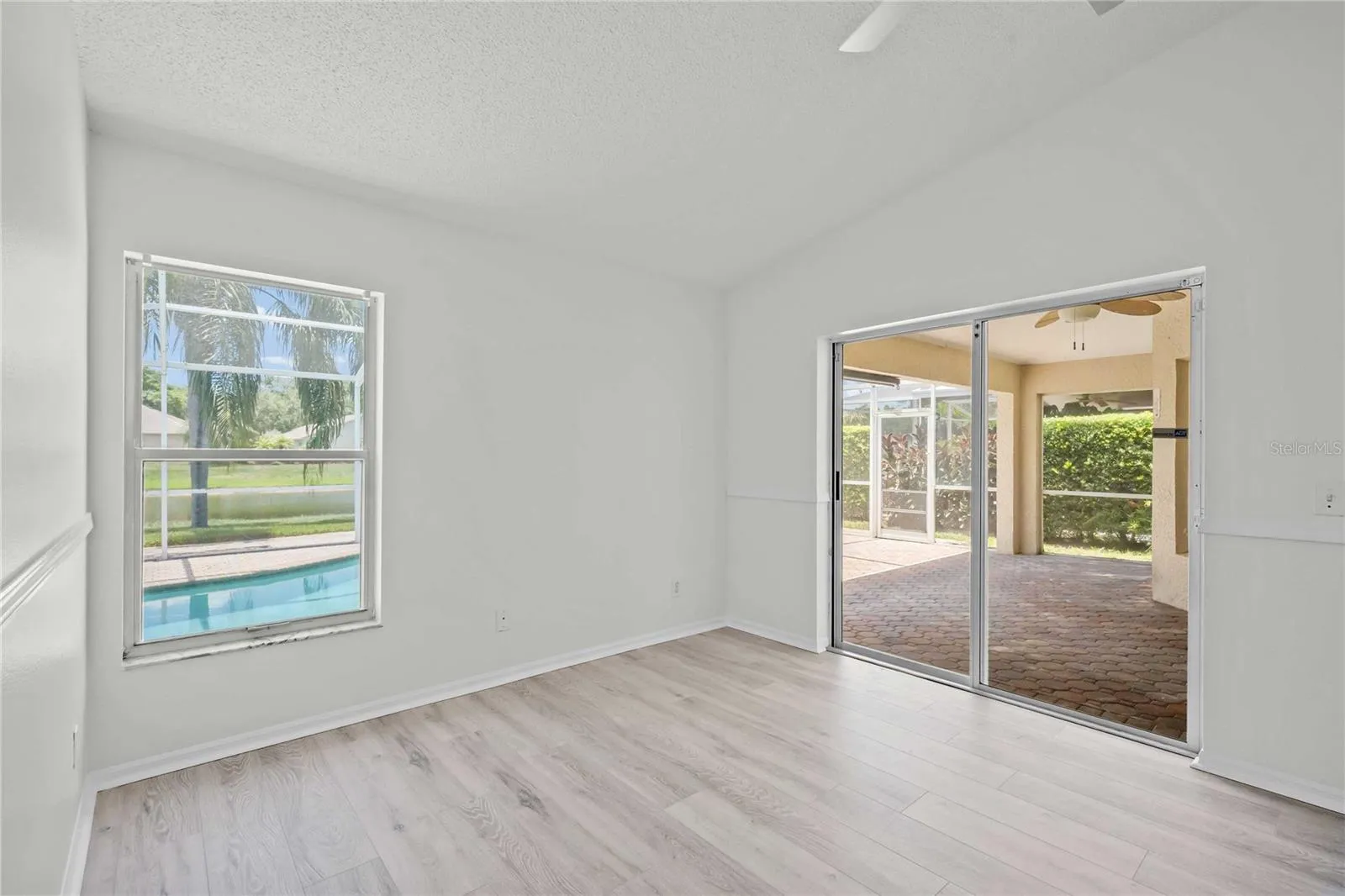 Primary Room - New Flooring, New Professional Paint, New Ceiling Fan, Sliding Glass Doors exit to Lanai &amp; Pool Area
