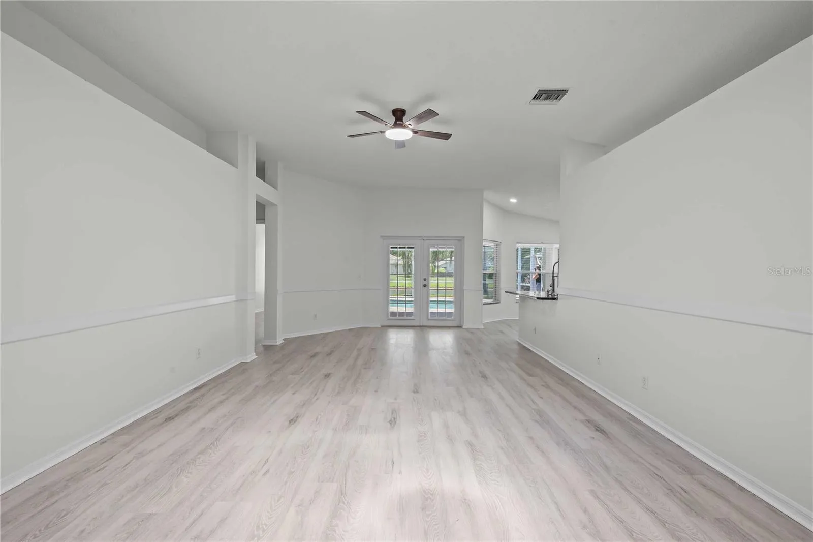 View of Liing Area and French Doors to the Pool - New Flooring, New Ceiling Fan Professional Paint