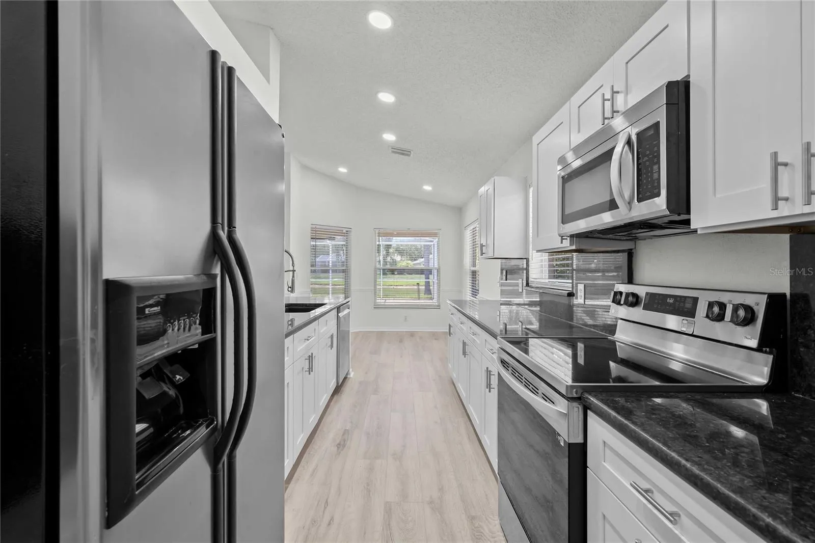 View of Kitchen and Eat In Area - New Kitchen Cabinets, New Flooring, New Recessed Lighting, New Ceiling Fans, and More!