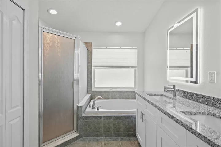 Primary Bathroom - New Dual Vanity & Cabinets, New Granite Countertops, New Mirror, New Professional Paint. Bathroom has Garden Soaker Tub & Shower Stall