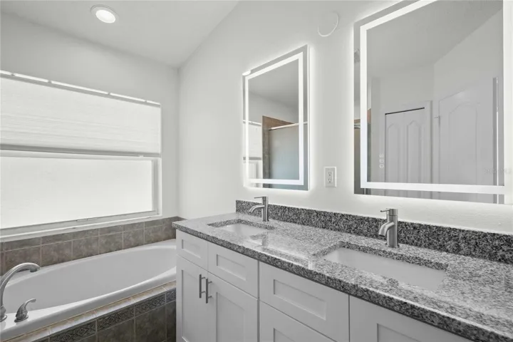 Primary Bathroom - New Dual Vanity & Cabinets, New Granite Countertops, New Mirror, New Professional Paint. Bathroom has Garden Soaker Tub & Shower Stall