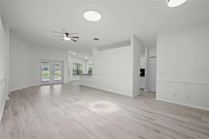 View of LivingArea, French Doors to the Pool, Kitchen Entry - New Flooring, New Ceiling Fan Professional Paint