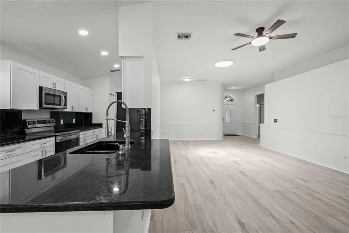 View of Living & Kitchen Area. New Kitchen Cabinets, New Flooring, New Recessed Lighting, New Ceiling Fans, and More!