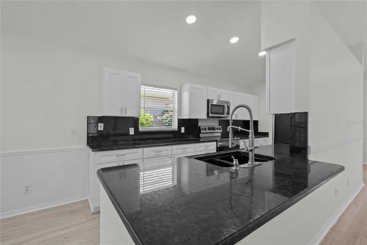 View of Living & Kitchen Area. New Kitchen Cabinets, New Flooring, New Recessed Lighting, New Ceiling Fans, and More!