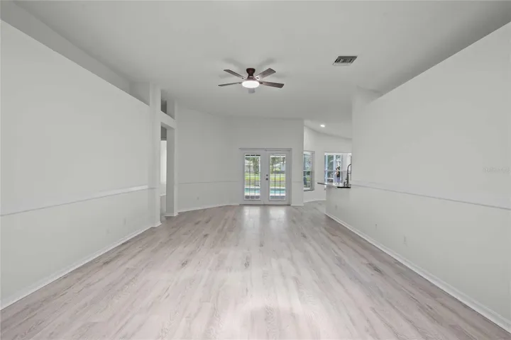 View of Liing Area and French Doors to the Pool - New Flooring, New Ceiling Fan Professional Paint