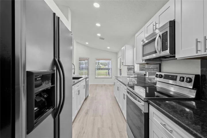 View of Kitchen and Eat In Area - New Kitchen Cabinets, New Flooring, New Recessed Lighting, New Ceiling Fans, and More!