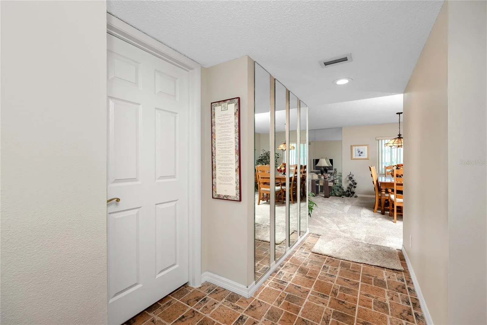 Facing into the living room from the front door. Door to left is primary, hall to right is guest bathroom and bedroom