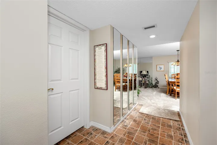 Facing into the living room from the front door. Door to left is primary, hall to right is guest bathroom and bedroom
