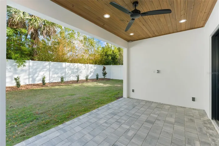 The large covered lanai has paver decking, a tongue & groove wood ceiling, it is pre-plumbed for a future summer kitchen.