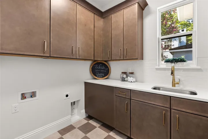 The laundry room is fun and functional!  From the checkerboard pattern on the floor, to the stunning cabinets and quartz countertops, this room has natural light, incredible storage space, creating an amazing area to work in.