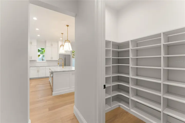 The enormous, walk-in pantry closet has built-in shelving, providing a substantial amount of storage.